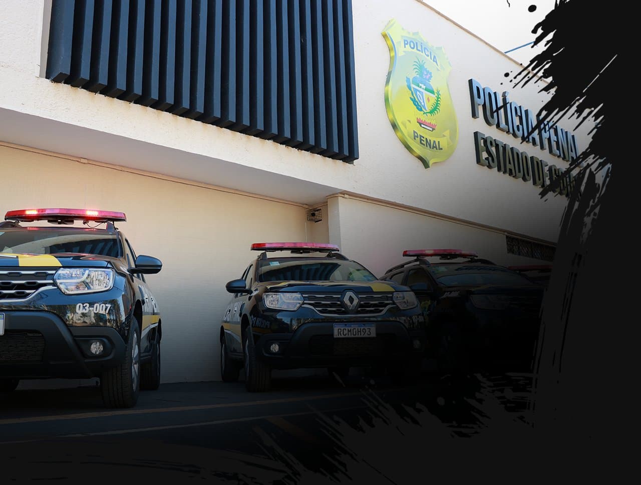 Viaturas da Polícia Penal do Estado de Goiás estacionadas em frente à fachada com o brasão da instituição